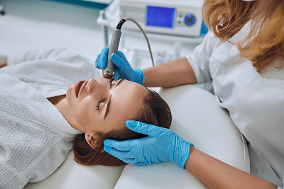Client receiving a device-based facial treatment